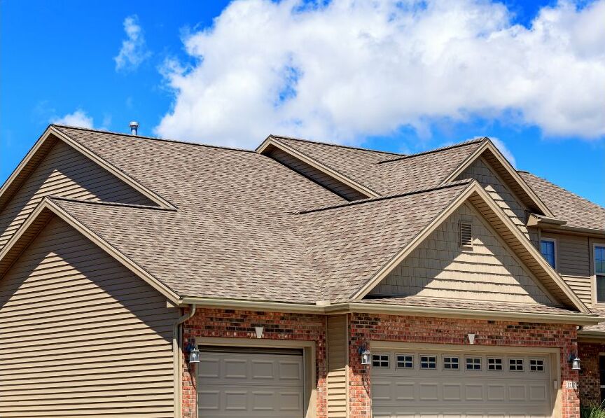 A home with a new roof with a blue sky in the background.